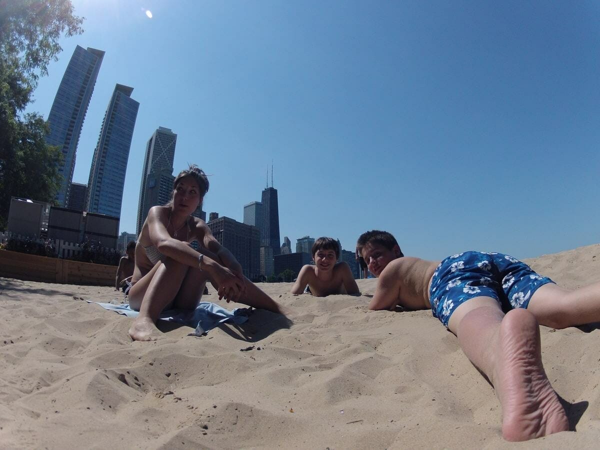 Chicos estirados en la arena de Olive Park Beach de Chicago
